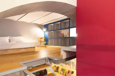 a room with a bed and a red wall at Trastevere Loft in Rome