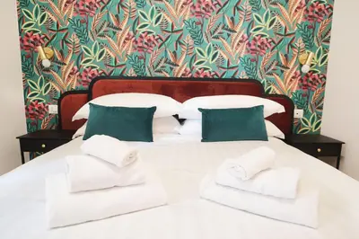 a bedroom with a white bed with green pillows at San Cosimato 40 guesthouse in Rome