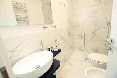 a white bathroom with a sink and a toilet at San Cosimato 40 guesthouse in Rome