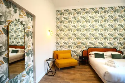a bedroom with two beds and a yellow chair at San Cosimato 40 guesthouse in Rome