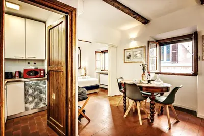 a kitchen and dining room with a table and chairs at MAYA RHOME TRASTEVERE in Rome