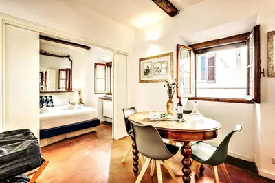a room with a table and chairs and a bed at MAYA RHOME TRASTEVERE in Rome