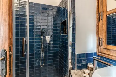 a blue tiled bathroom with a shower at MAYA RHOME TRASTEVERE in Rome