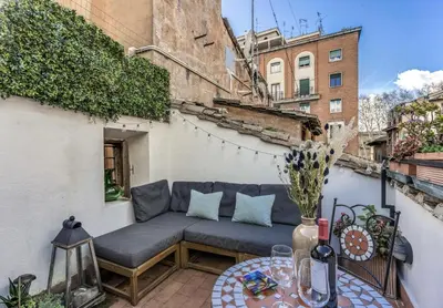 a patio with a couch and a table at MAYA RHOME TRASTEVERE in Rome