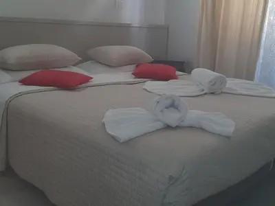 two beds with white towels and red pillows on them at GUEST HOUSE FIDARDO in Rome