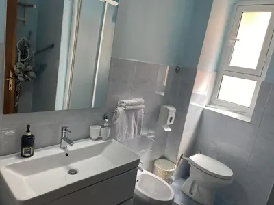 a bathroom with a sink and a toilet and a mirror at GUEST HOUSE FIDARDO in Rome