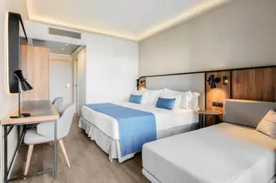 a hotel room with two beds and a chair at Barceló Roma in Rome