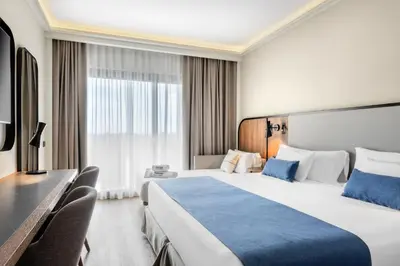 a hotel room with a large bed and a television at Barceló Roma in Rome