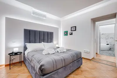 a bedroom with a large bed with two towels on it at Spanish Steps Suite - Zucchelli in Rome