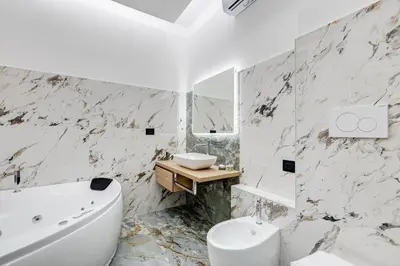 a white bathroom with a tub and a sink at Spanish Steps Suite - Zucchelli in Rome