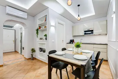 a kitchen and dining room with a table and chairs at Spanish Steps Suite - Zucchelli in Rome