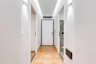 a hallway with a white door and a tile floor at Spanish Steps Suite - Zucchelli in Rome
