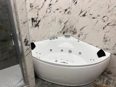 a white bath tub in a bathroom with marble walls at Spanish Steps Suite - Zucchelli in Rome