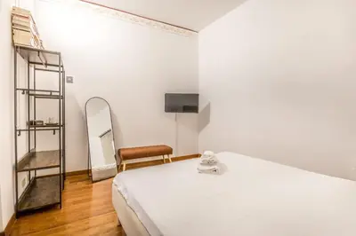 a white bedroom with a bed and a mirror at Casa Ghetto 13 in Rome