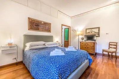 a bedroom with a large bed and a chair at Casa Ghetto 13 in Rome