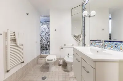 a white bathroom with a toilet and a sink at Casa Ghetto 13 in Rome