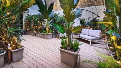 a patio with plants and a couch and lights at The Central View - DolceVite in Rome