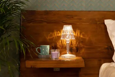 a table with a lamp and two cups on it at The Central View - DolceVite in Rome