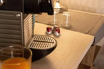 a coffee machine on a table with a glass at The Central View - DolceVite in Rome