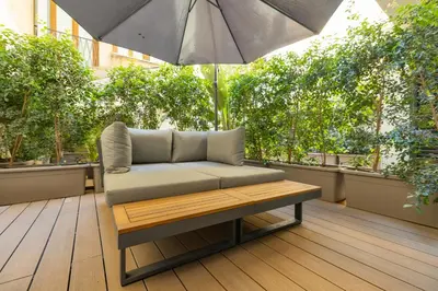 a bench sitting on a patio with an umbrella at The Central View - DolceVite in Rome