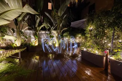 a garden with lights and plants on a wooden floor at The Central View - DolceVite in Rome