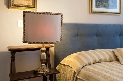 a lamp on a table next to a bed at Elegante grande appartamento con 4 stanze - Vaticano e centro Roma in Rome