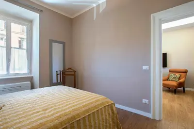 a bedroom with a bed and a chair and a window at Elegante grande appartamento con 4 stanze - Vaticano e centro Roma in Rome