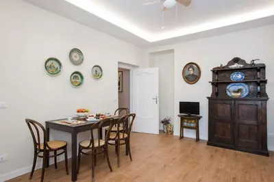 a dining room with a table and some plates on the wall at Elegante grande appartamento con 4 stanze - Vaticano e centro Roma in Rome