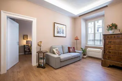 a living room with a couch and a window at Elegante grande appartamento con 4 stanze - Vaticano e centro Roma in Rome