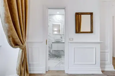 a bathroom with a mirror and a door with a sink at Monti Suites Cavour in Rome