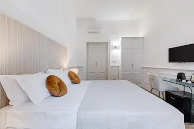 a white bedroom with a large white bed with pillows at Monti Suites Cavour in Rome