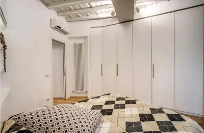 a kitchen with white cabinets and a wooden table at suity I cozy leutari 23 in Rome