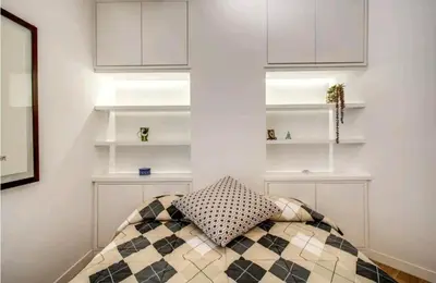 a room with white shelves and a pillow on a bed at suity I cozy leutari 23 in Rome