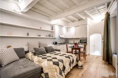 a bedroom with a bed and a couch and a kitchen at suity I cozy leutari 23 in Rome