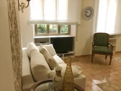 a living room with a white couch and a tv at Foscari Holiday House in Rome