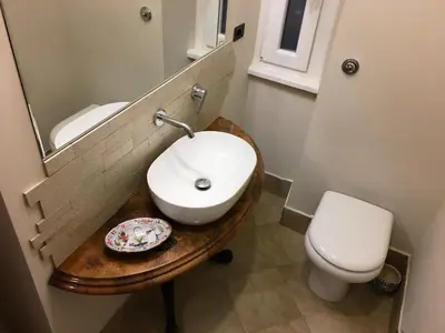 a bathroom with a sink and a toilet and a mirror at Foscari Holiday House in Rome
