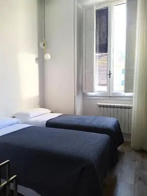 two beds in a room with two windows at NiK in Rome