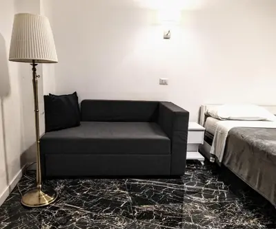 a couch in a room with a bed and a lamp at NiK in Rome