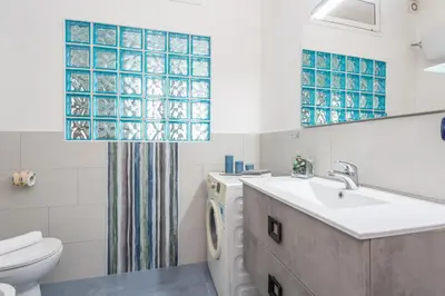 a bathroom with a sink and a toilet and a mirror at Modern 2BDR apartment vibrant Prati neighborhood in Rome