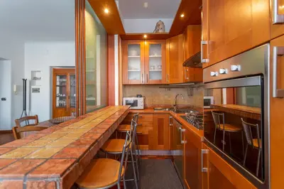 a kitchen with wooden cabinets and a large wooden counter top at Modern 2BDR apartment vibrant Prati neighborhood in Rome