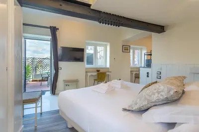 a bedroom with a large white bed and a balcony at the B rooftop apartment in Rome