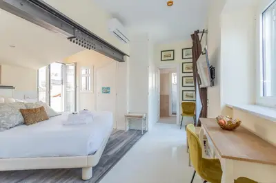 a bedroom with a white bed and a wooden table at the B rooftop apartment in Rome