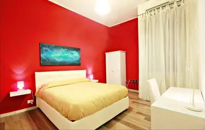 a red bedroom with a white bed and a white desk at Colosseum - Big and comfortable apartment in Rome