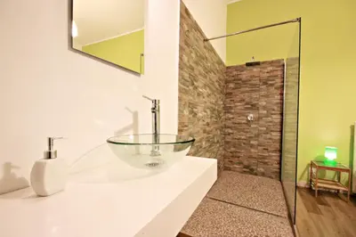 a bathroom with a glass bowl sink on a counter at Colosseum - Big and comfortable apartment in Rome