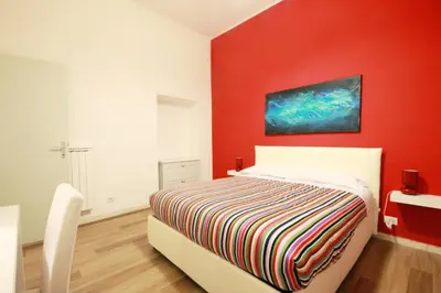 a bedroom with a bed with a red wall at Colosseum - Big and comfortable apartment in Rome