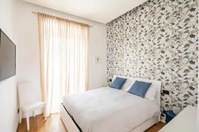 a bedroom with a white bed with blue pillows at Casa Borghese - Your perfect stay in Rome in Rome