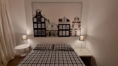a bedroom with a bed with two lamps on the wall at La Casa di G. in Rome