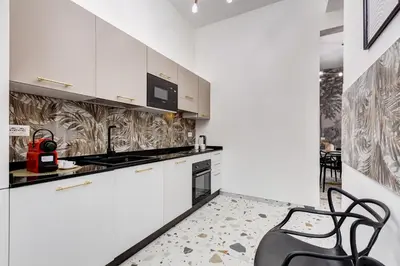 a kitchen with white cabinets and a table and chairs at Villa Chiara - a new Luxury Star is born in Rome! in Rome