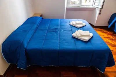 a blue bed with two towels on top of it at Alexander Vatican House in Rome
