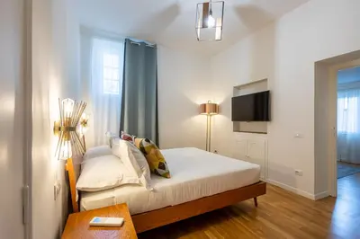 a white bedroom with a bed and a tv at Vatican Vita Apartment in Rome